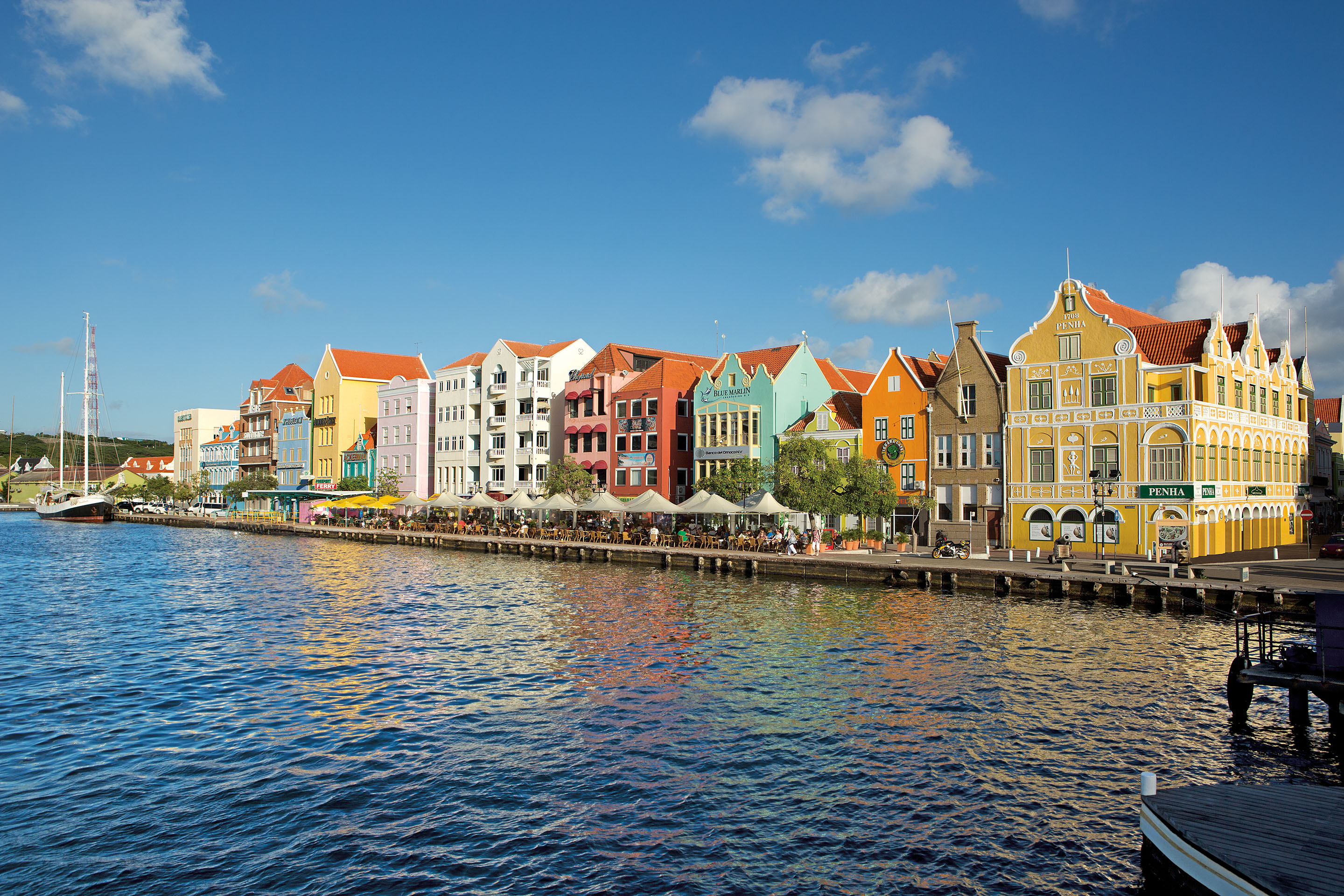 Beautiful view of Curaçao architecture from a boat. Docks along water lined with colorful building.