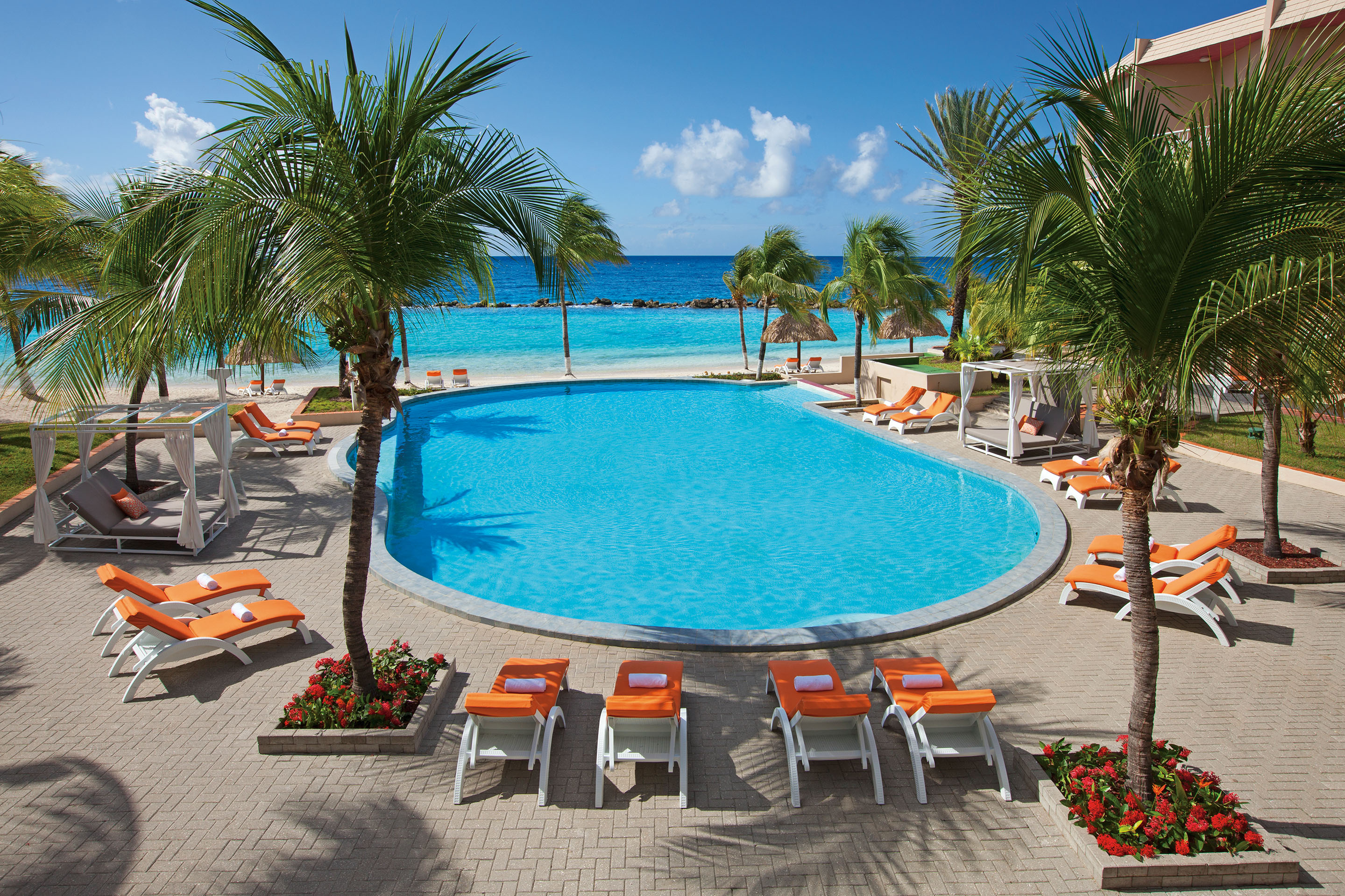 Luxury swimming pool of tropical hotel overlooking the ocean.